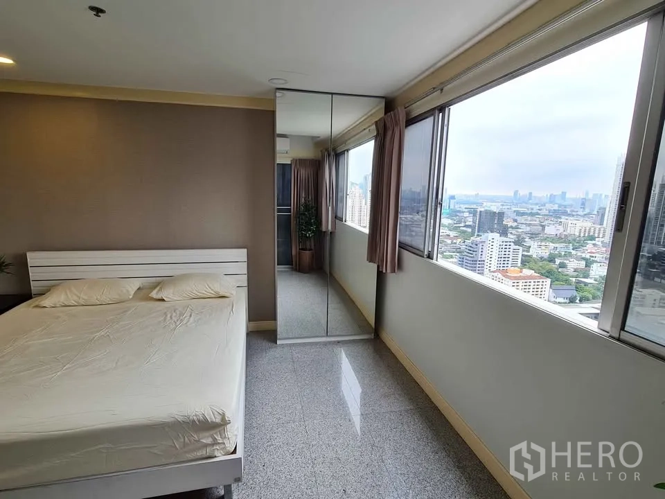 คอนโด for rent in Khlong Toei, Bangkok - ห้องนอนมีหน้าต่างบานใหญ่ ตู้เสื้อผ้าบานกระจก และวิวสกายไลน์เมือง.