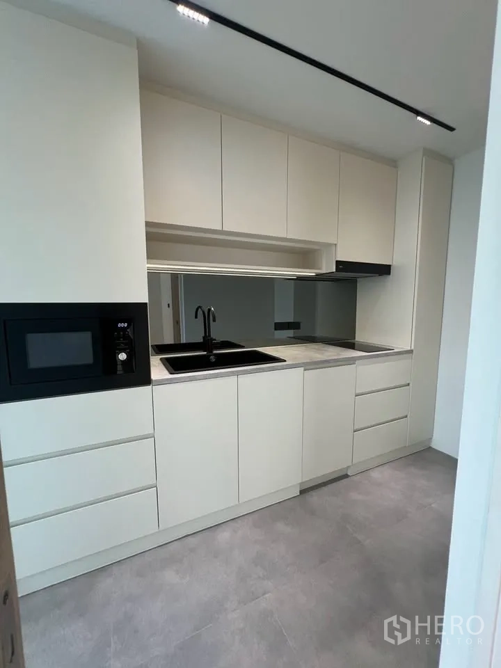 联排别墅 for rent in Prawet, Bangkok - 现代厨房全景，收纳充足，灰色地面。