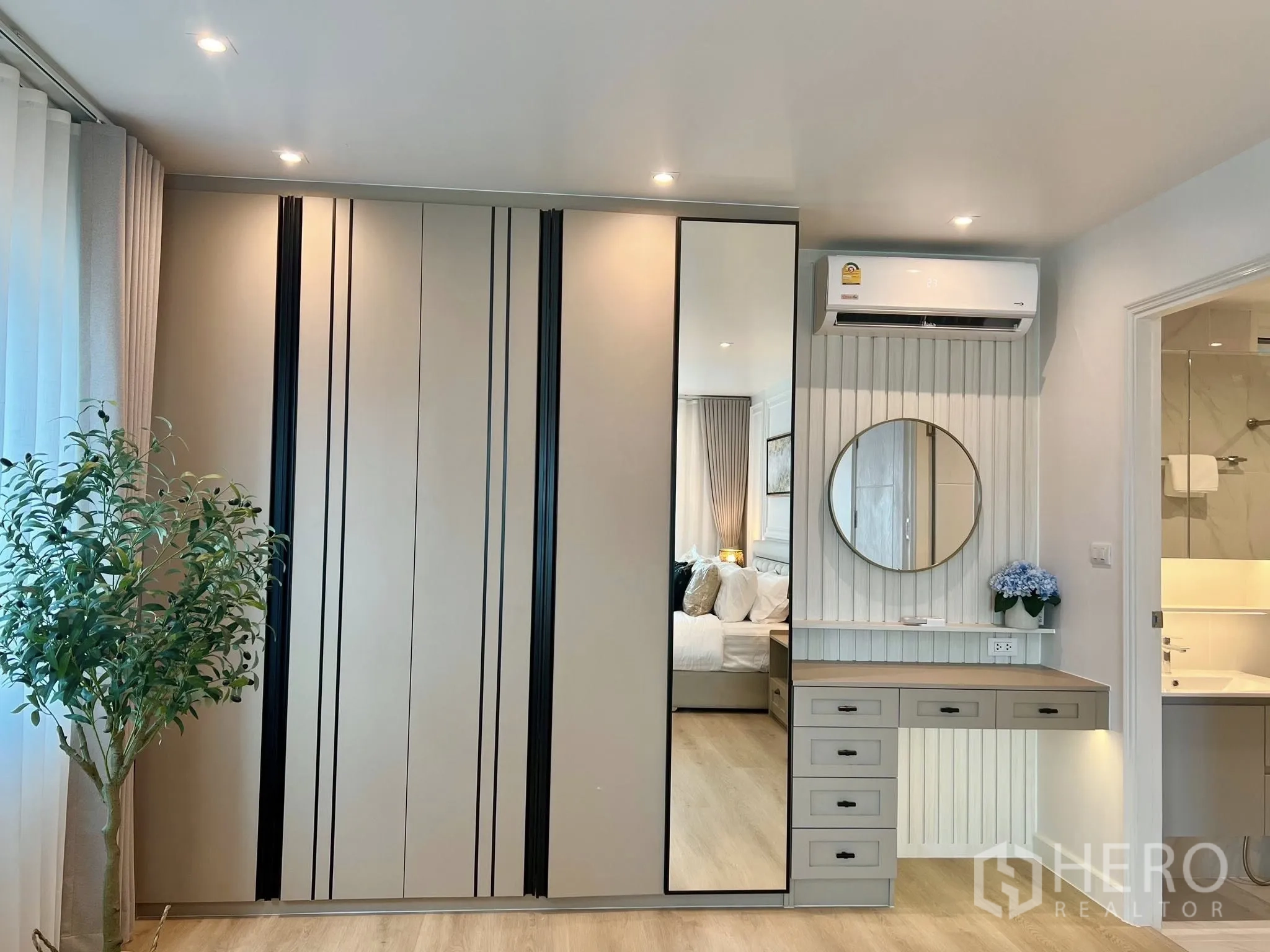公寓 for rent or sale in Yan Nawa, Bangkok - 内置衣柜配镜面门与梳妆台，墙上空调，现代卧室浅木地板。