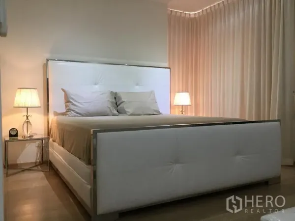 公寓 出租或出售在Watthana, Bangkok - 主卧温馨，白色软包床与床头灯相映成趣。