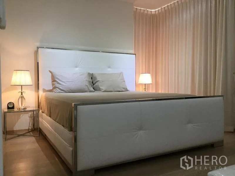 公寓 出租或出售在Watthana, Bangkok - 主卧温馨，白色软包床与床头灯相映成趣。