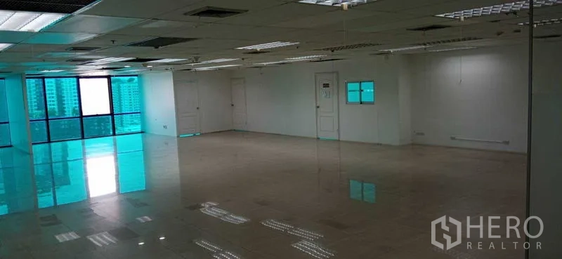 สำนักงาน ให้เช่าในHuai Khwang, Bangkok - ออฟฟิศว่างพร้อมหน้าต่างบานใหญ่ ประตูหลายจุด พื้นเงา และฝ้าแขวน.