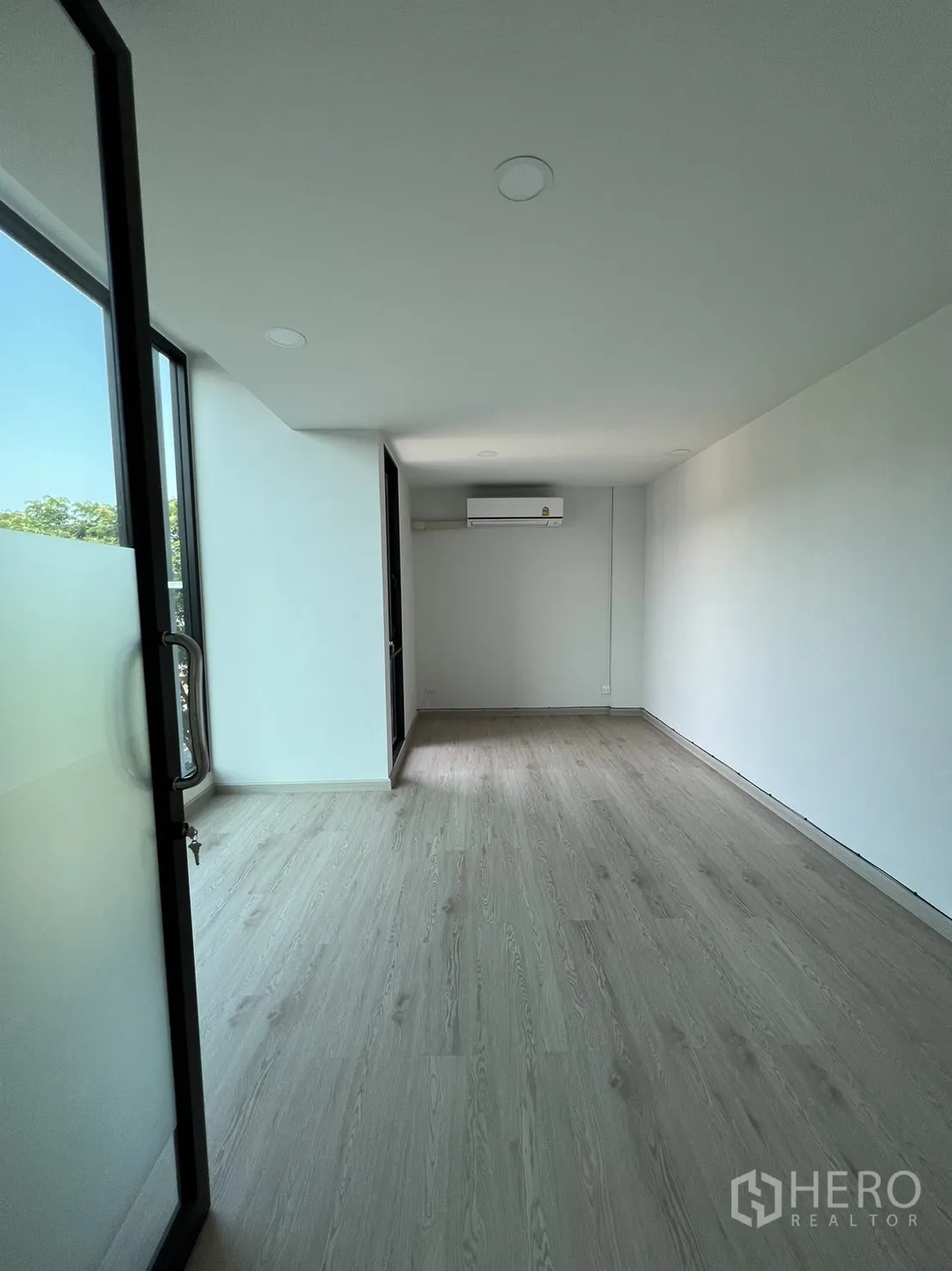 Home Office for rent in Bang Phli, Samut Prakan - Narrow room with balcony access, wood flooring and full‑height window.