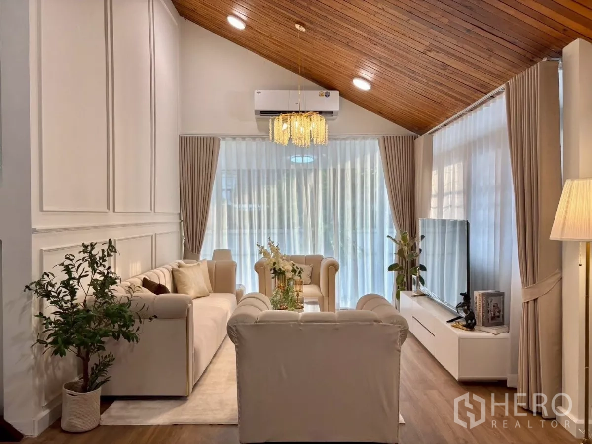 Detached House for rent in Huai Khwang, Bangkok - Bright living room with vaulted wood ceiling, chandelier and cream sofas
