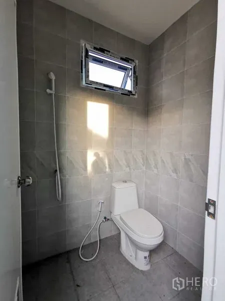 Warehouse for rent in Bang Na, Bangkok - Tiled restroom with toilet, handheld shower and ventilation window