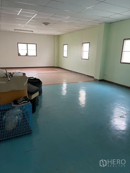 Warehouse for rent in Khan Na Yao, Bangkok - Bright upper-floor room with tiled ceiling and windows, ideal for office use inside the warehouse.