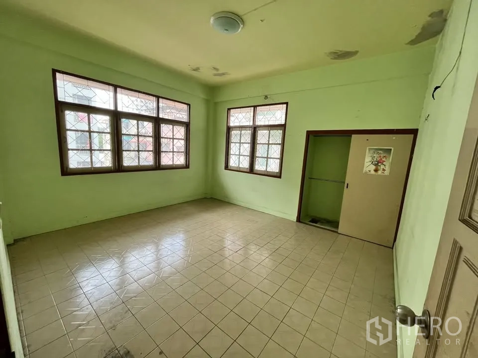 Detached House for rent in Suan Luang, Bangkok - Light-filled bedroom with tiled floors and sliding wardrobe.