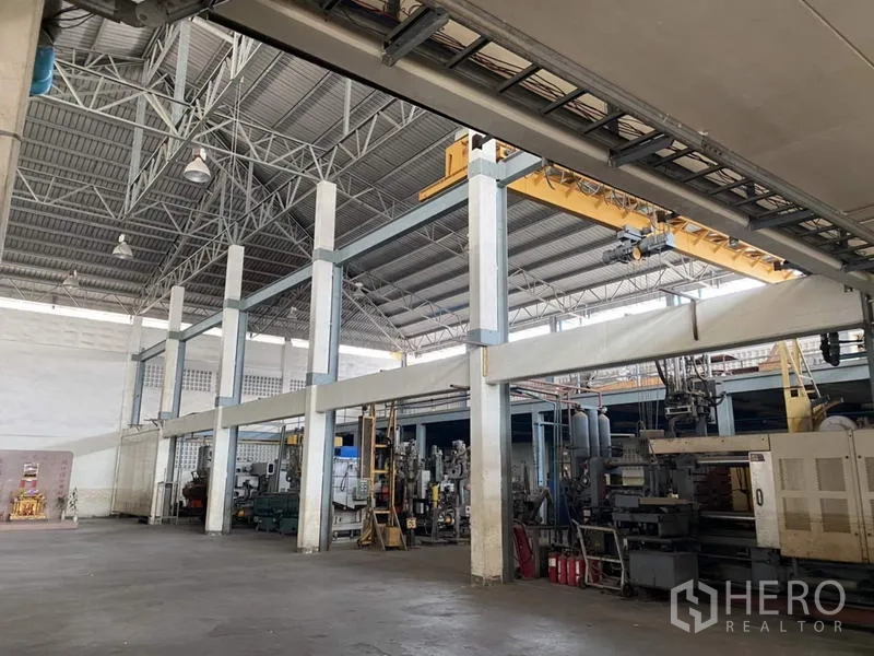 Factory for sale in Khlong Luang, Pathum Thani - Factory hall featuring an overhead gantry crane beneath a high-clearance roof.