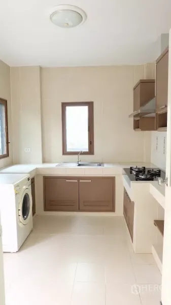 Detached House for sale in Bang Phli, Samut Prakan - Fitted kitchen with tiled walls, gas hob, hood, sink and washing machine.
