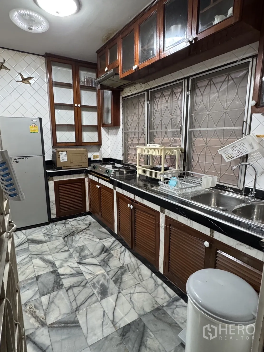 独立式住宅 出租在Min Buri, Bangkok - 独立厨房，石纹地砖、木柜、炉灶与双水槽。