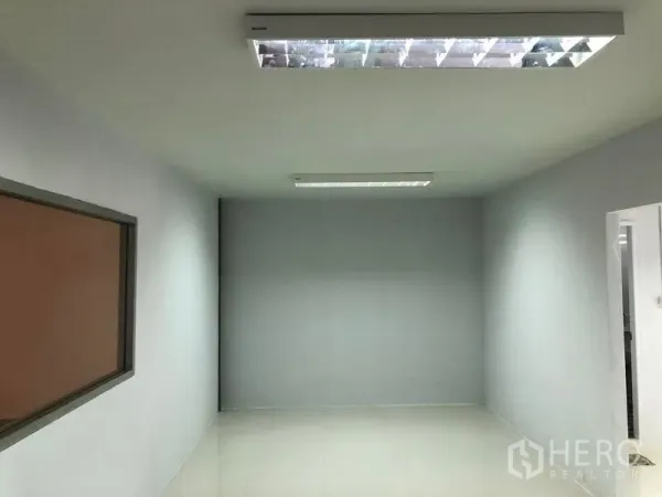 Warehouse for rent in Khlong Luang, Pathum Thani - Clean office room inside the warehouse with window and fluorescent ceiling lights.