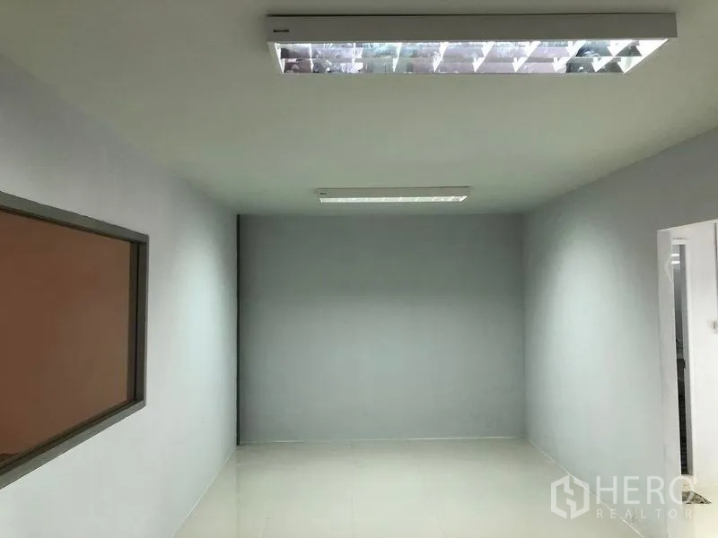 Warehouse for rent in Khlong Luang, Pathum Thani - Clean office room inside the warehouse with window and fluorescent ceiling lights.