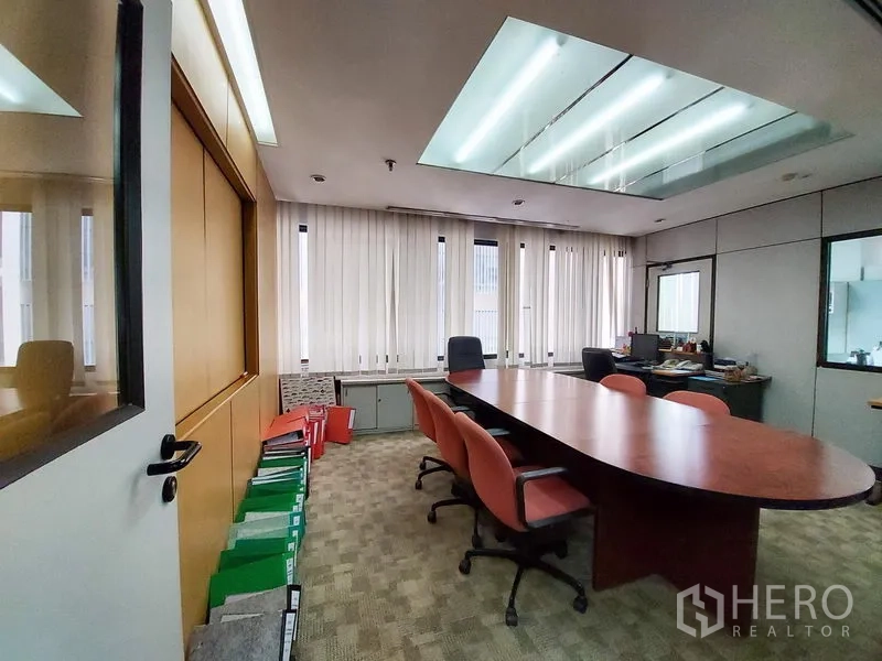 สำนักงาน ให้เช่าในRatchathewi, Bangkok - ห้องประชุมโต๊ะยาวทรงวงรี เก้าอี้ผู้บริหาร ไฟสกายไลต์บนเพดาน และมู่ลี่แนวตั้งข้างผนังกระจก
