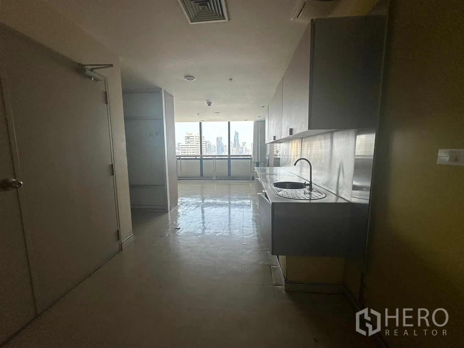 Office Space for rent in Khlong Toei, Bangkok - Pantry corridor with stainless-steel sink and a window toward the city.