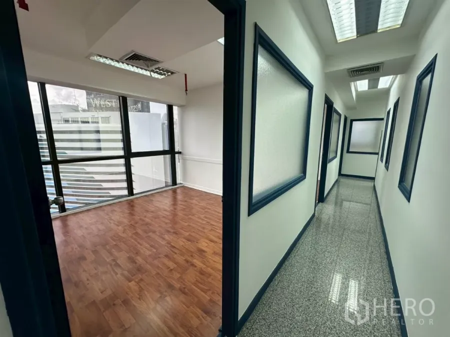 Office Space for rent in Khlong Toei, Bangkok - Hallway leading to a glass-walled office with city views.