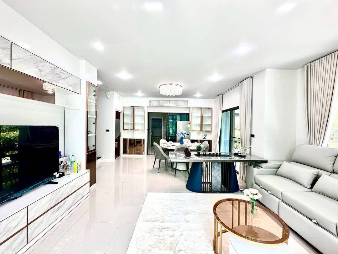 Detached House for rent in Bang Kapi, Bangkok - Open-plan living and dining room with chandelier and sliding glass doors.