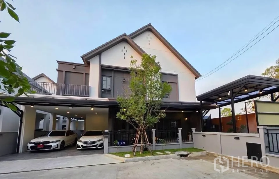บ้านเดี่ยว for sale in Bang Phli, Samut Prakan - ภาพด้านหน้าบ้านเดี่ยวสมัยใหม่ มีรั้วและที่จอดรถในร่มขนาดใหญ่.