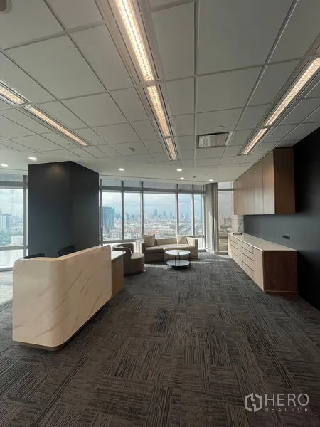 Office Space for rent in Dusit, Bangkok - Welcoming reception with stone counter and built-in pantry facing lounge and city view.