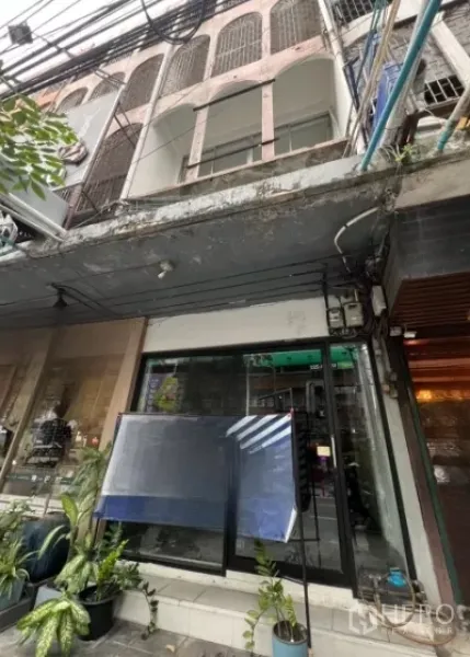 Shophouse for rent in Watthana, Bangkok - Three-storey shophouse facade with glass storefront and balconies on a lively Thonglor lane.