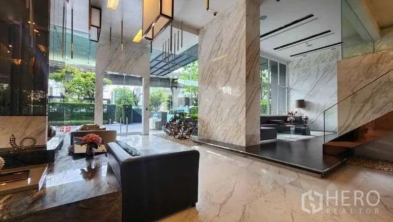 Condominium for rent in Khlong Toei, Bangkok - Elegant marble lobby with seating and floor-to-ceiling windows.