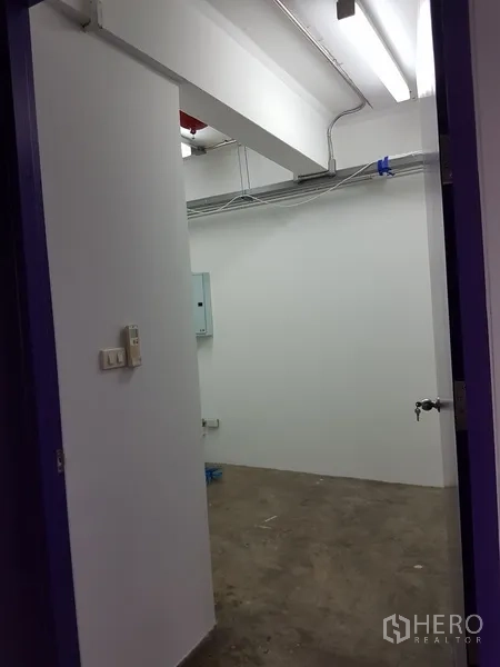 Home Office for sale in Khlong Toei, Bangkok - Utility room entrance with white walls and fluorescent lighting.