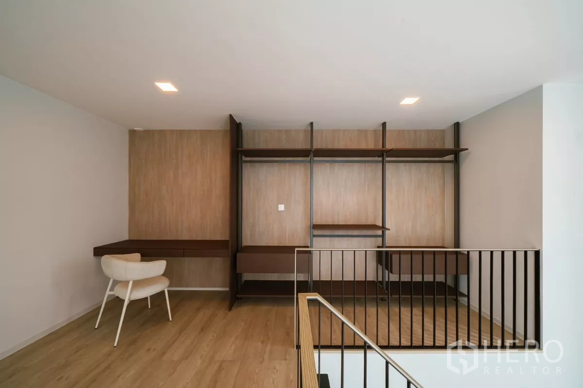 Detached House for rent or sale in Saphan Sung, Bangkok - Mezzanine study with open shelving, work desk and wood accent wall.