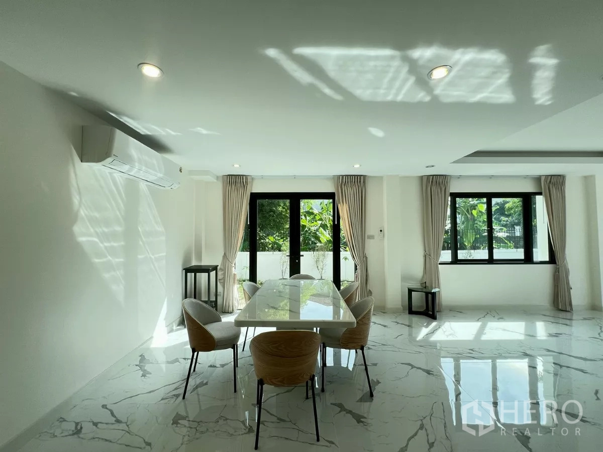 独立式住宅 出租在Suan Luang, Bangkok - 阳光餐区，通过黑框窗户可见绿意。