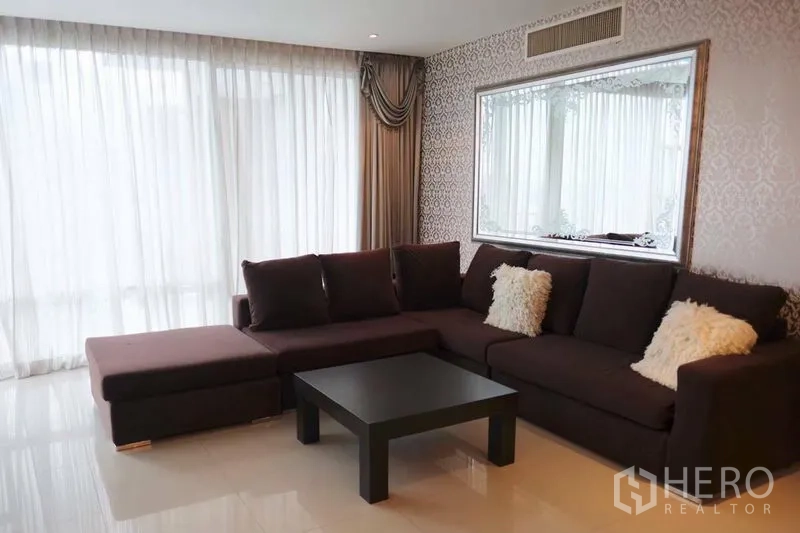 公寓 出租在Watthana, Bangkok - 明亮客厅，L型沙发、落地窗帘和装饰镜
