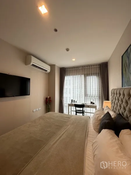 公寓 出租或出售在Khlong Toei, Bangkok - 主卧朝窗视角，带书桌、壁挂电视与空调。