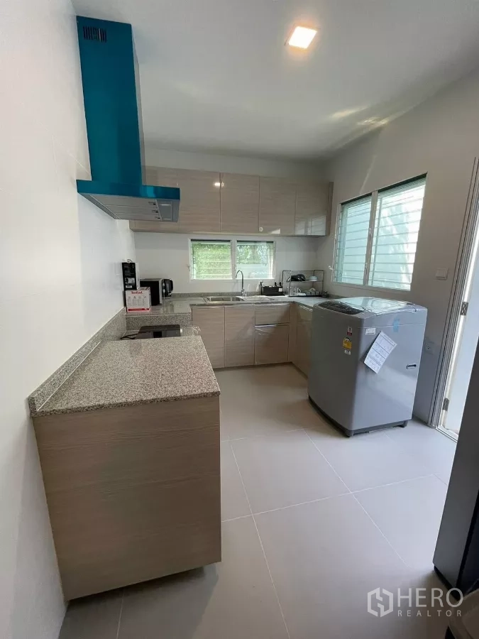Detached House for rent in Prawet, Bangkok - Separate kitchen with granite countertops, cabinetry and range hood.