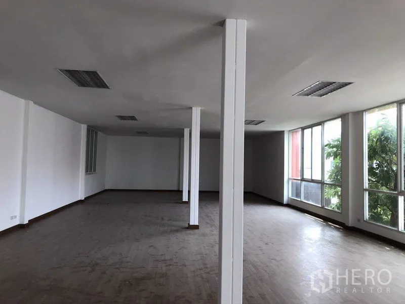 Factory for rent in Samut Prakan - Open‑plan second‑floor office with large windows and support columns.