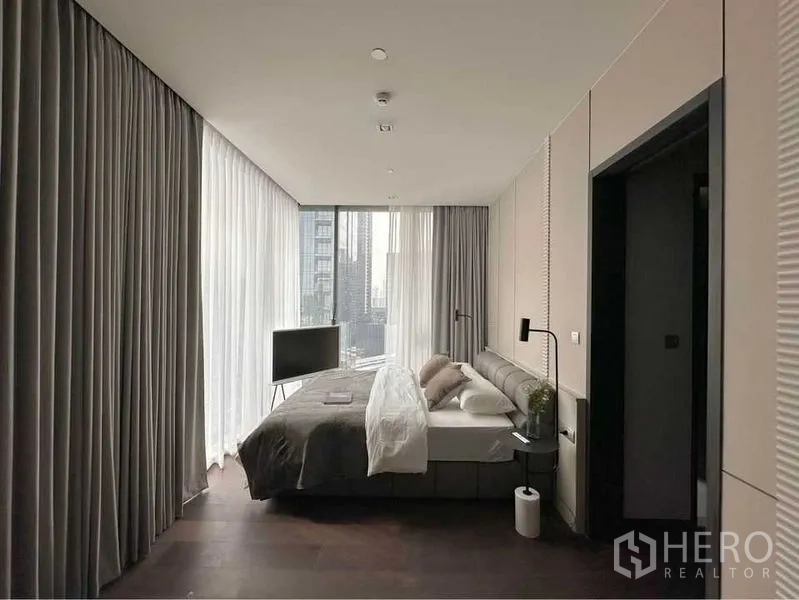 คอนโด ให้เช่าหรือขายในWatthana, Bangkok - ห้องนอนกว้าง ผนังกระจกสองด้าน ทีวีวางพื้น และวิวสกายไลน์