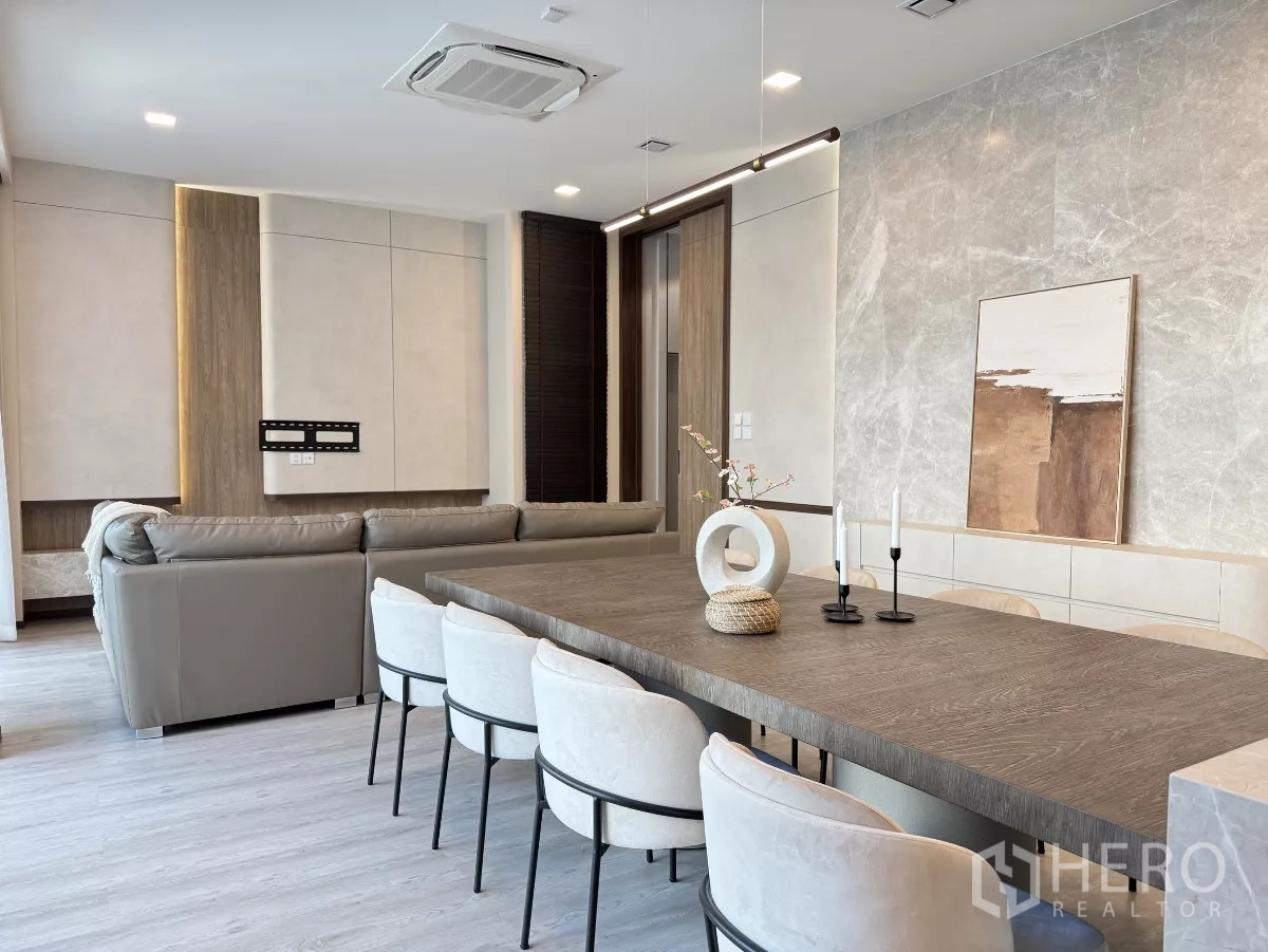 Detached House for rent in Saphan Sung, Bangkok - Open-plan dining and lounge with a long wooden table, pendant lighting and a marble accent wall.