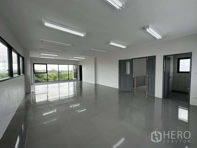 Factory for rent or sale in Bang Bua Thong, Nonthaburi - Spacious upper-floor office with multiple doors and ample lighting.