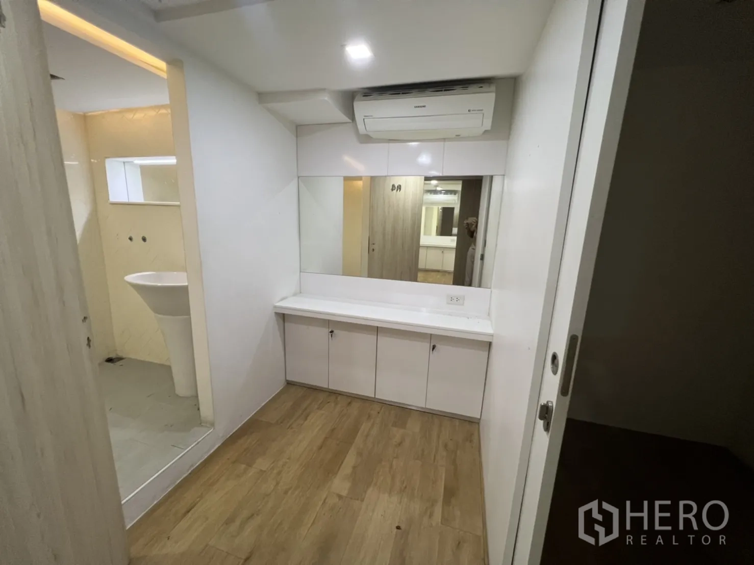 Shophouse for rent or sale in Watthana, Bangkok - Tiled washroom with pedestal sink and a long horizontal mirror opening.