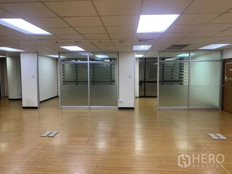 Office Space for rent in Bang Rak, Bangkok - Open-plan office with wood floors, drop ceiling lights and frosted glass-partitioned meeting rooms.