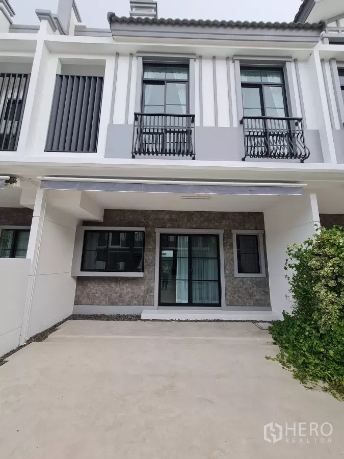 联排别墅 出租在Bang Phli, Samut Prakan - 现代两层联排别墅外观，带遮雨双车位与阳台栏杆