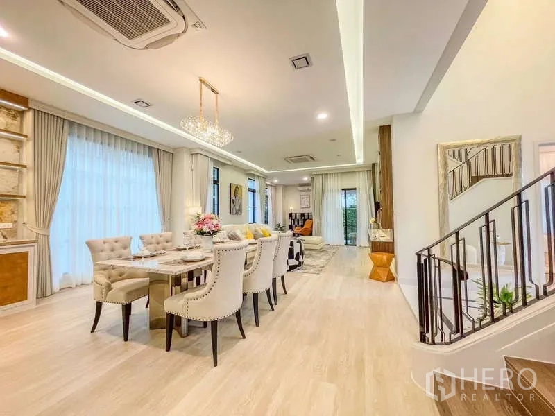 Detached House for rent in Saphan Sung, Bangkok - Open-plan dining and living area with light wood floors and balcony doors.