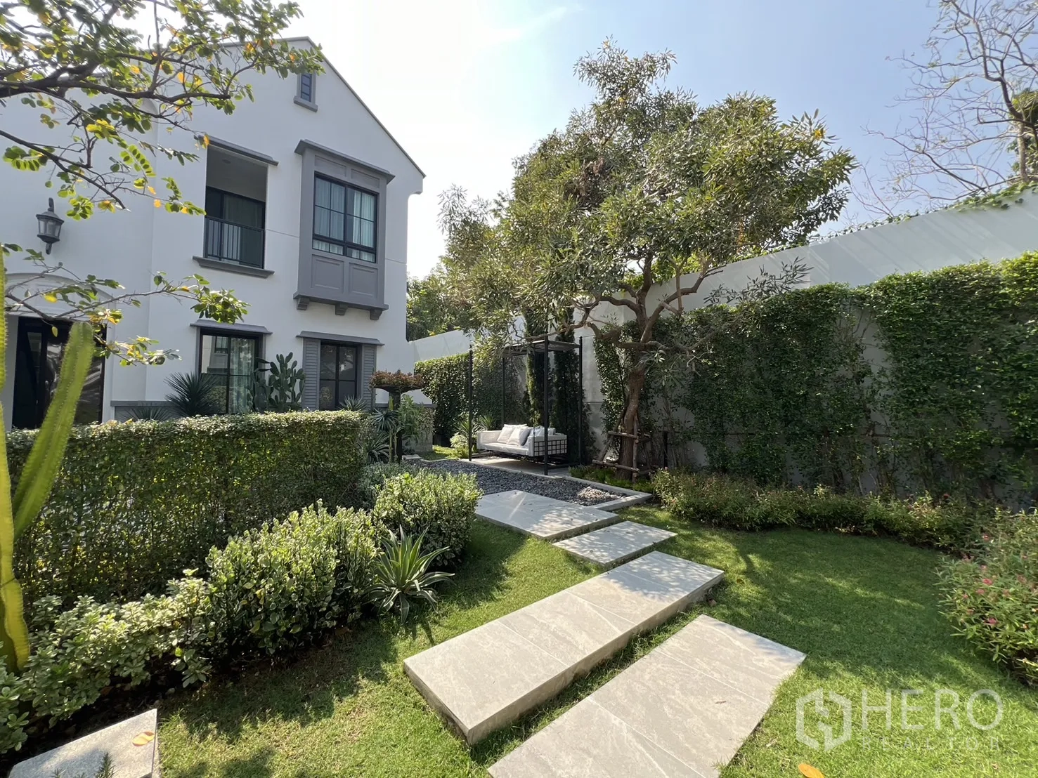 Detached House for rent in Saphan Sung, Bangkok - Backyard lawn with stone path, trimmed hedges and shady trees.