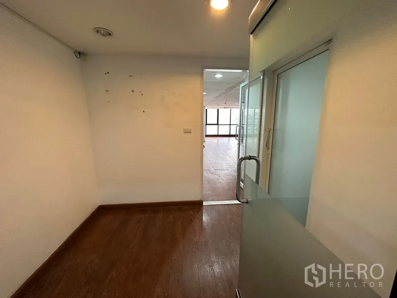 办公空间 出租在Ratchathewi, Bangkok - 小型入口区，磨砂玻璃门通向开放式办公室，木地板与白墙。