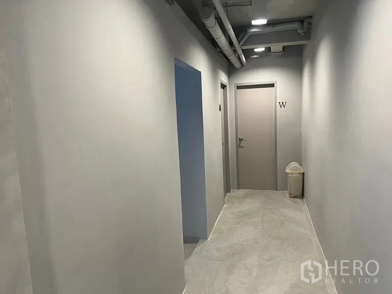 Retail Space for rent in Watthana, Bangkok - Hallway with restrooms and modern lighting inside the retail building in Watthana.