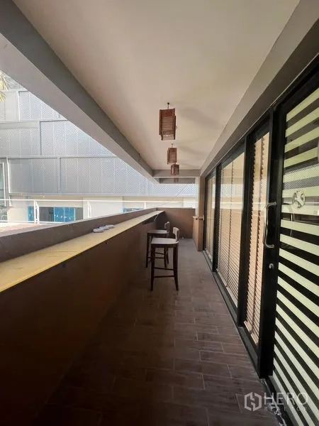 Retail Space for rent or sale in Khlong Toei, Bangkok - Balcony walkway with high counter and stool outside sliding doors.