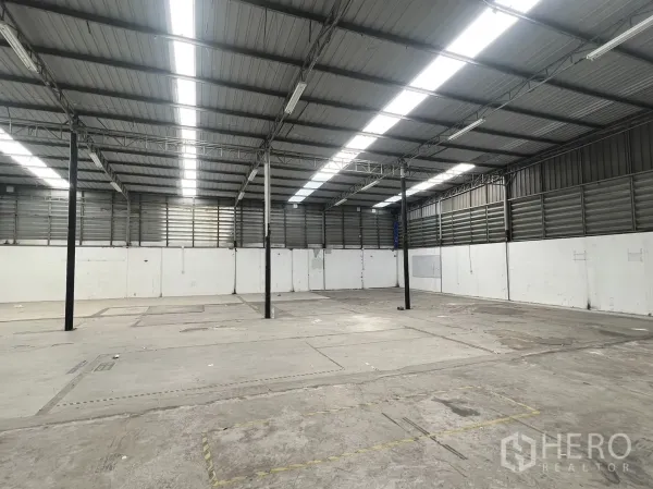 货栈 出租在Suan Luang, Bangkok - 开放式仓储区，混凝土地面、钢柱与明亮长条灯。