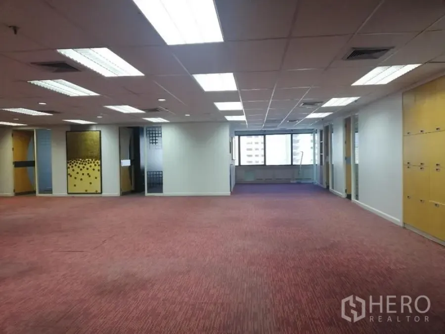 办公空间 出租在Watthana, Bangkok - 开放工作区，红色地毯与分隔房间，顶灯充足并面向城市窗景。