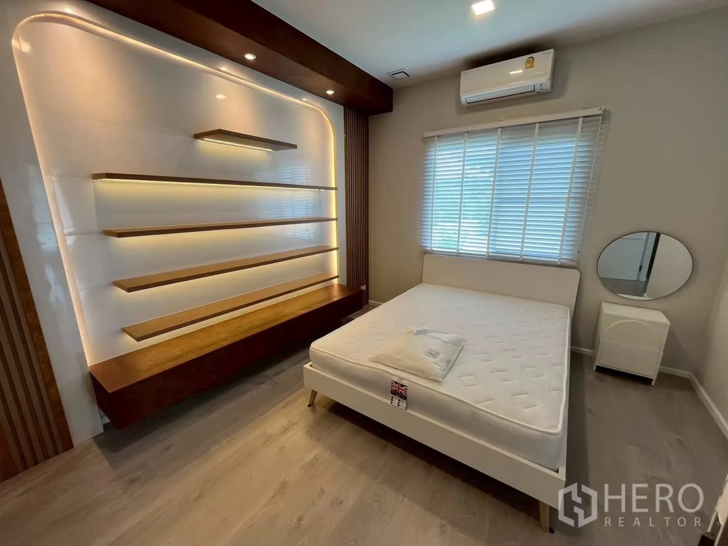 Detached House for rent in Prawet, Bangkok - Bedroom with illuminated floating shelves and a white bed.
