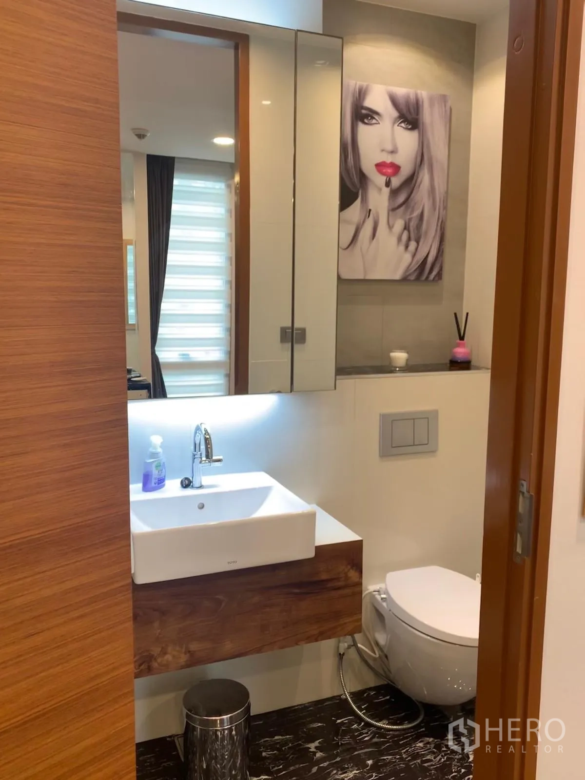 Condominium for sale in Khlong Toei, Bangkok - Powder room with vanity, mirror cabinets and soft lighting.