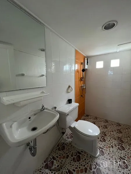 Detached House for rent in Saphan Sung, Bangkok - Bathroom with sink, toilet and shower area with patterned floor tiles.