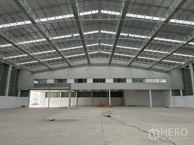 工厂 出租在Pathum Thani - 厂房内部面对夹层办公室与大型卷帘门。