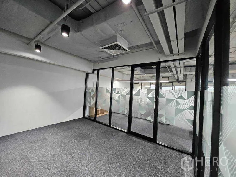 Office Space for rent in Ratchathewi, Bangkok - Empty private room with carpet tiles and glass partition featuring geometric frosted film.