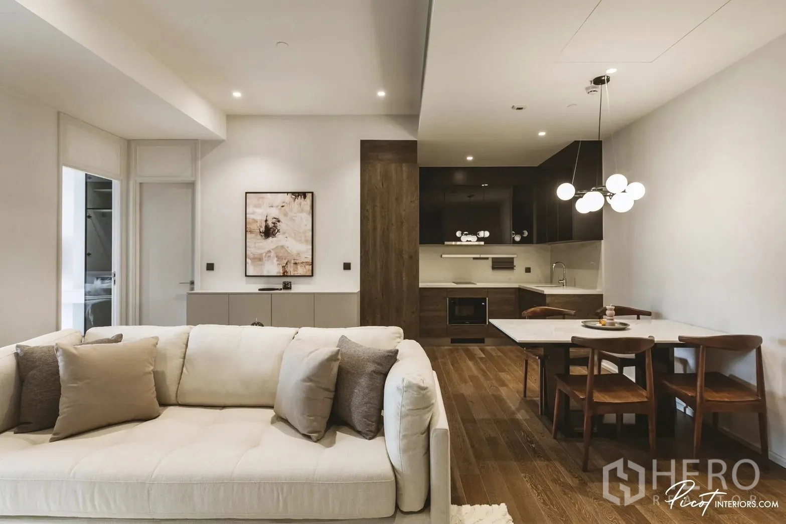 คอนโด for rent in Pathum Wan, Bangkok - โถงนั่งเล่น-ทานอาหาร-ครัวแบบโอเพ่นแพลนพร้อมโซฟาโทนอ่อนและโต๊ะกลม